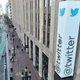 A sign outside a big concrete building of Twitter headquarters reads @twitter with the blue twitter bird above it.